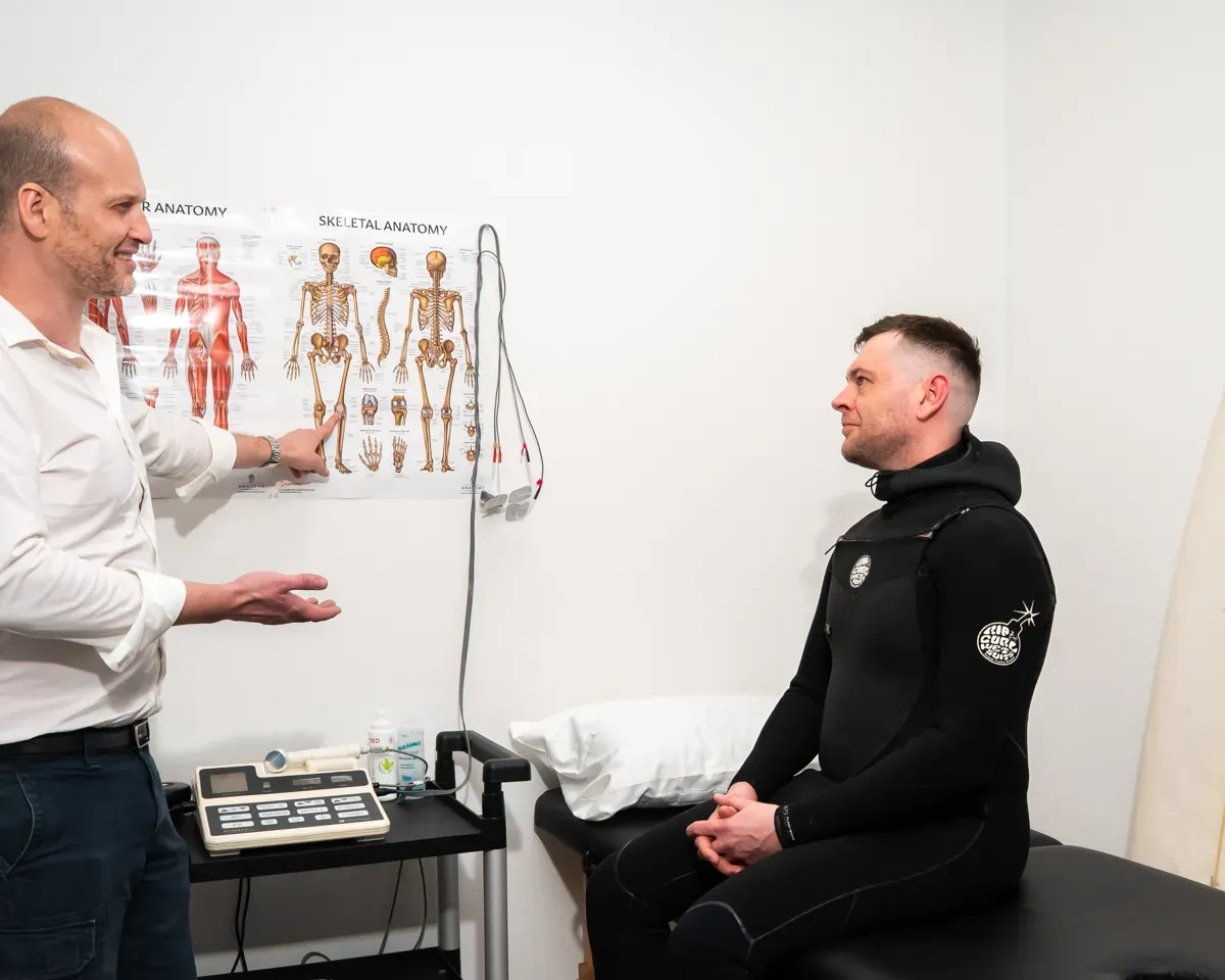 Dr. Ed explaining an anatomy chart to a patient