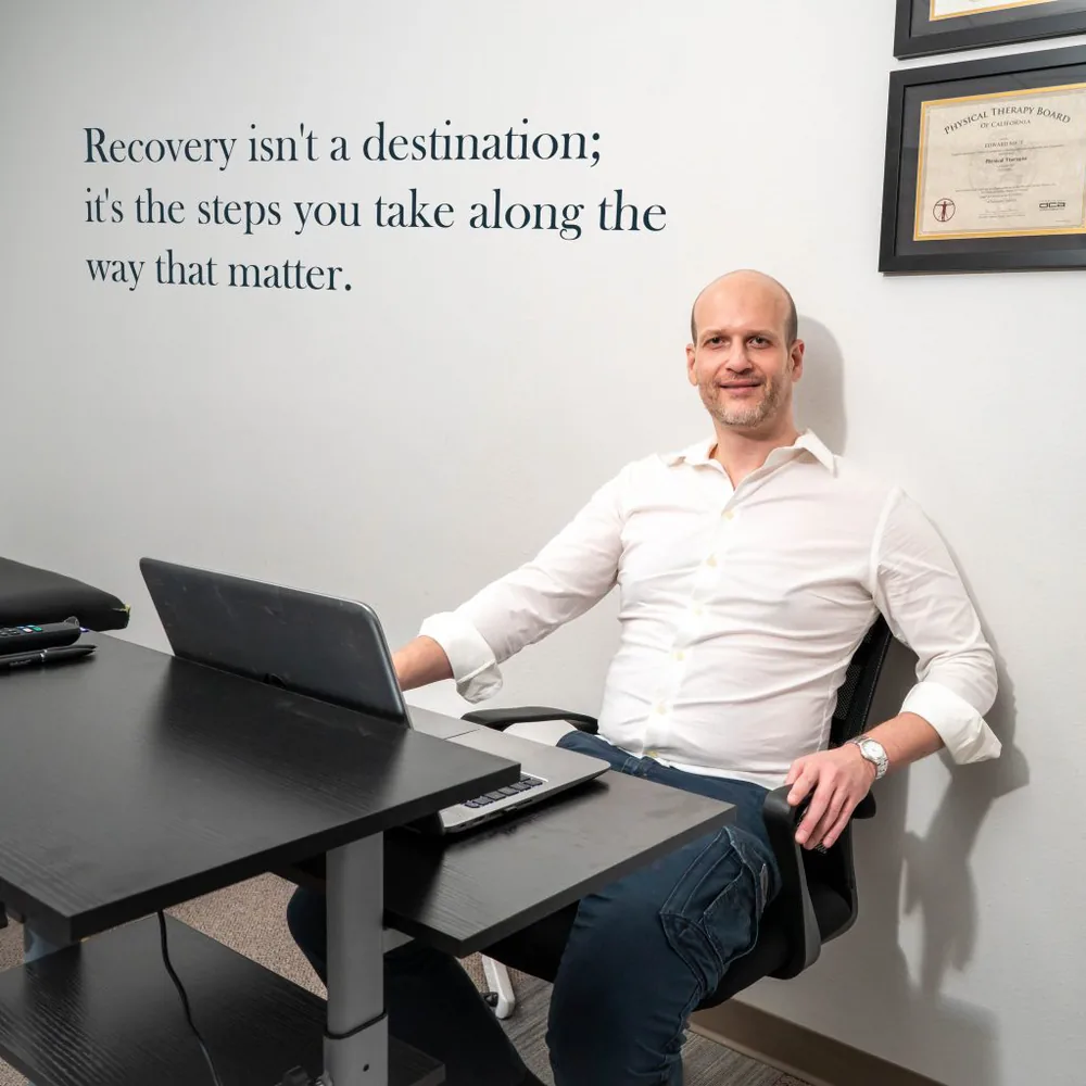 Dr. Edward Shut, DPT, at his desk in the Chatsworth Physical Therapy clinic