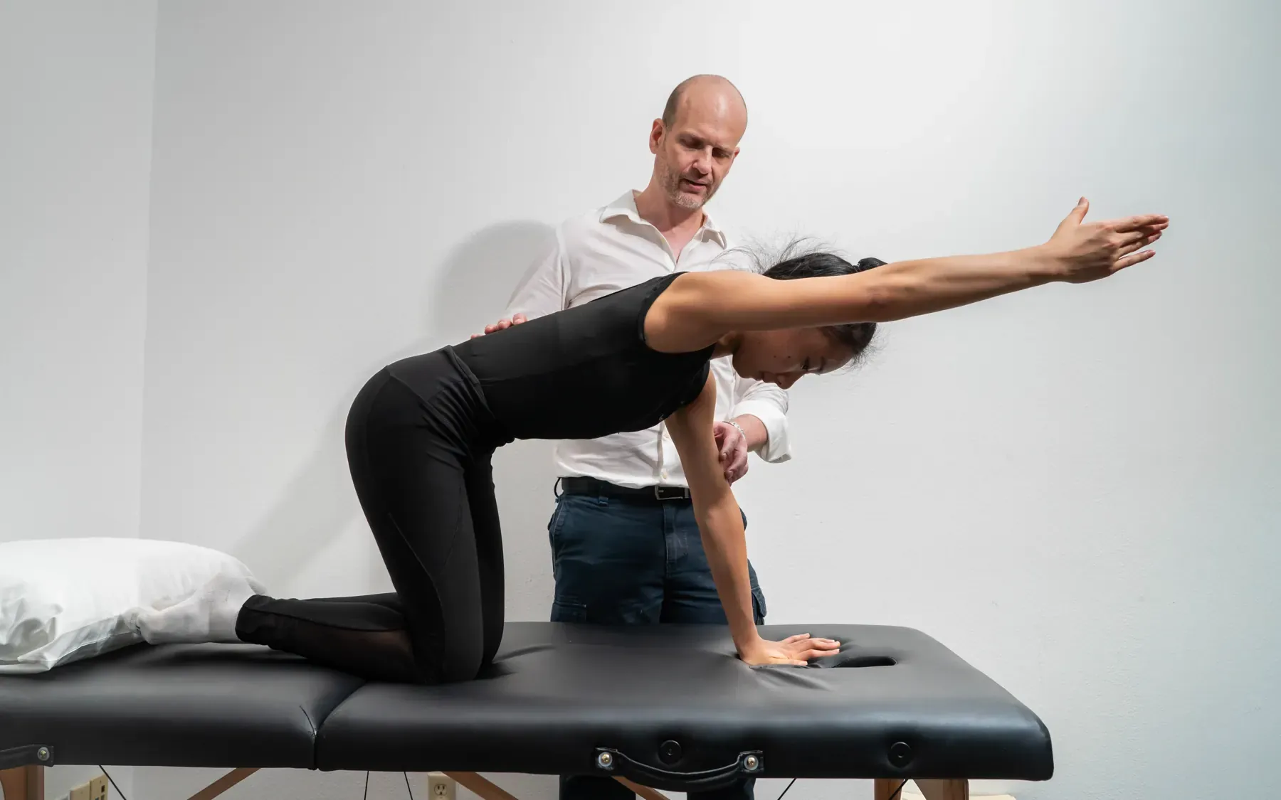 Dr. Ed Shut guiding a patient through a back exercise on the treatment table at Chatsworth Physical Therapy